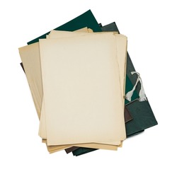 Old yellowed sheets of paper lie in a pile on a paper folder.