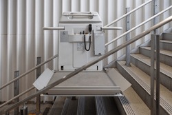a stair lift for the disabled, wheel chair lift for stairs. Mechanical chair lift taking disabled or aged people up and down stairs.