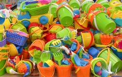 Children's plastic toys. New toy bucket, blade, rake, cars in the store. Sale of children's products. 
