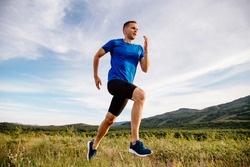 sporty man runner running on mountain plateau in summer