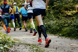 group of runners athletes running in forest trail marathon