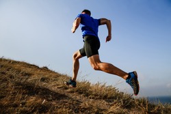 dynamic running uphill on trail male athlete runner side view