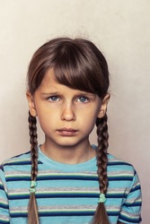 Little girl with two pigtails with a very sad, crying face