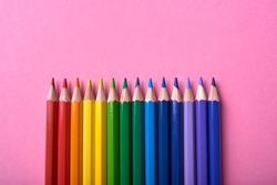 Colorful pencils of rainbow colors on pink pastel background, close up. Set of colorful pencils, copy space. Crayons. Top view, flat lay. Back to school, college concept. Abstract background