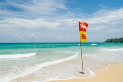 Danger for swimming red flag on beach.Caution sign that tourists  on the beach.Landscape clean sea white clouds soft daylight.Blue sea waves and sky on sand beach.