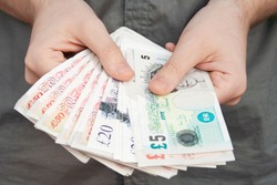 Pounds banknotes held by a man's hands