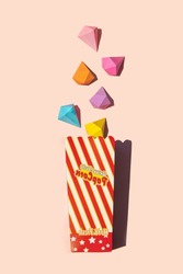 Pop corn box with colorful diamond shapes on pastel light pink background. Abundance concept. Creative food idea. Rich flavor inspiration.