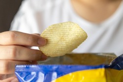 Hand hold potato chips with snack bag