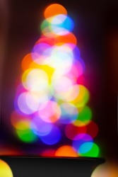 Magic circle colorful lights from black vase, foreground focusing bokeh formed triangle tree shape, vibrance colour for celebrate a festival party.
