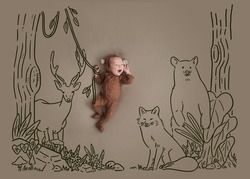 Little baby with drawing (doodle). Newborn wearing monkey bodysuit. Tarzan baby hanging vines in the forest among the herds are bear, deer and fox.