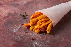 Fried French fries, in a paper bag, on an abstract background, no people, rustic,