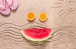 Summer wallpaper, drawing on sand, sea waves and sun, face shape of summer fruits, pink flip-flops, top view, no people,