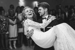 Groom admires happy bride laughing in his arms