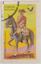 Circa 1976: A stamp printed in Cinderellas shows Uniform of the 11th Dragoons, Great Britain, Staffa Scotland.