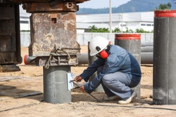 Technician checking graph last ten blow of spun pile driving from hydraulic drilling machines on construction site