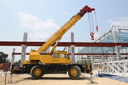 Crane operator and Mobile crane machine stand by waiting for lift steel roof truss under the construction building industrial factory