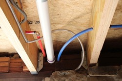 Electrical Wires, PEX and PVC Piping in a Wooden Floor Joist