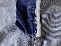 backside of jeans zipper, closeup. the edge of cloth or overlock was covered whit fabric