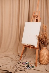 Wooden easel, dried flowers on a brown background
