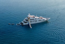 Big luxury white yacht anchoring in shallow water stands in the sea at sunset. Travel and vacation concept, marine entertainment