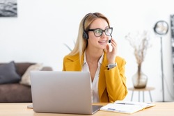 Assist call center. Portrait of smiling caucasian woman employee support services worker. Friendly female in headset with microphone working in office, client consultation concept