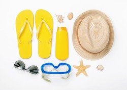 Variety beach accessories on white background. Vacation and travel items, top view