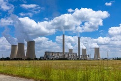Working coal fired power station in South Africa.  Grass field  in the foreground