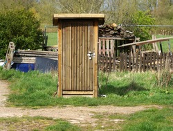 Solitary wooden outhouse  lavatory example       