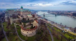 Budapest, Hungary - Aerial drone skyline view of Buda Castle Royal Palace with Szechenyi Chain Bridge and Parliament of Hungary on a cloudy winter day