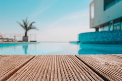 Empty wooden deck with swimming pool , Beautiful minimalist pool side view with clear blue sky . Vintage filter color apply .