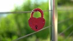 On the railing hangs a wedding lock of red in the form of a heart. A wedding tradition all over the world to hinder the lock. Monument on the wedding day. Inscription on the lock advice and love 4k