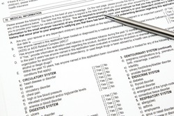 A health insurance application medical information section with a pen ready to be filled out.