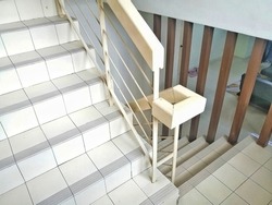double storey house stairs. the stairs connect lower and upper floor. white stair with wooden hand rail.