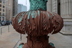 Cast iron, forged antique street lamp with paint peeling off over time in front of the City Hall