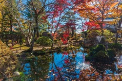Fantastic autumn scene in Japan. The ruins of castle iss aflame with autumn colors.