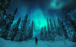 Man watching Aurora borealis in lapland winter