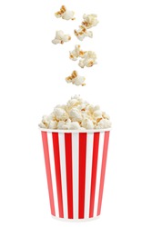 Popcorn falling into a red striped paper cup, isolated on white background