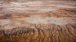 Natural texture of drought and cracked surface of land inside hot zone of Yellowstone national park, Wyoming, USA.