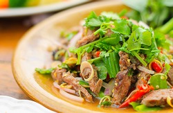 Spicy salad of roasted beef , Thai style food ; selective focus with blur background.