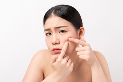 Asian woman squeezing pimples on her face, skin care lifestyle concept.
