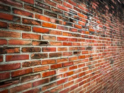 Old cracked red brick wall with perspective view