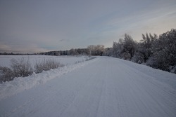 tire tracks in the snow, winter road, empty road in winter bends, covered with snow path, winter landscape	