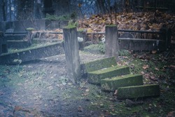 old damaged crooked unstable concrete steps of cemetery grave place stairway. Overgrown with moss. Burial ground, Latvia graveyard