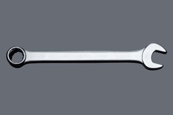 silver spanner wrench iron hand tool for repair and service plumbing instrument isolated on gray glass background with reflection top view, nobody.