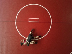 Female wrestlers competing on a red mat. View from above. 