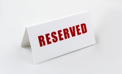 Reserved sign standing on the white background. Letters are red. 