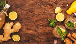 Ginger Ale Cocktail with Beer, Lime, Lemon and Mint in glaass on wooden table, top view 