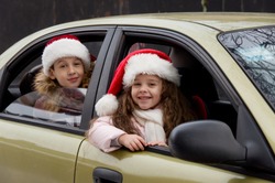 two happy children in Christmas clothes sitting in the car