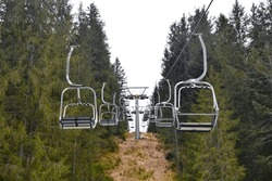 The early spring landscape at an out of season ski resort near the Alpine village of Cima Sappada, Carnia, Udine, Friuli-Venezia Giulia, NE Italy. Empty chairlifts and an intermediate support tower
