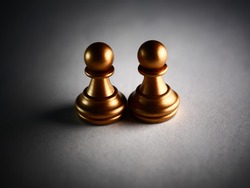A closeup shot of metallic gold pawn chess pieces